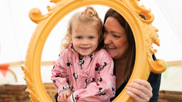 A mum and her daughter laugh and play in the Summer of Play tent in Saltram's garden